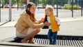 Cute baby boy holding mothers hand while jumping on trampoline at playground. Happy parenting, family having time together, kids Royalty Free Stock Photo