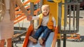 Cute baby boy holding mothers hand while riding down the slide on playground. Happy parenting, family having time together, kids Royalty Free Stock Photo