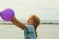 Cute baby boy holds violet toy balloon in hands Royalty Free Stock Photo