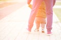 Cute baby boy learning to walk and make his first steps. mom is holding his hand. child`s feet close up, view from the Royalty Free Stock Photo