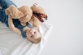 Cute baby boy lies on floor and plays with toy plush bear Royalty Free Stock Photo