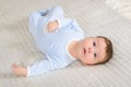 Cute baby boy is lying on the gray carpet Royalty Free Stock Photo