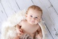 Cute baby boy 8 months old lies and looks at the camera, baby like an angel with white curly hair Royalty Free Stock Photo