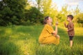 Cute baby boy and mother blowing on a dandelions on green lawn. Summertime photography for ad or blog about motherhood Royalty Free Stock Photo