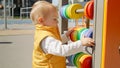 Cute baby boy playing with colorful abacus outdoors. Children developments, kids education, baby learning Royalty Free Stock Photo