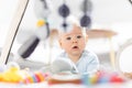 Cute baby boy playing with hanging toys arch on mat at home Baby activity and play center for early infant development