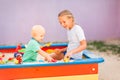 Cute baby boy playing with his sister in the sandbox Royalty Free Stock Photo