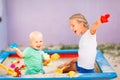 Cute baby boy playing with his sister in the sandbox Royalty Free Stock Photo