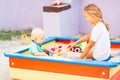 Cute baby boy playing with his sister in the sandbox Royalty Free Stock Photo