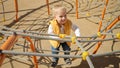 Cute baby boy playing on the playground and climbing up the rope spider web. Children playing outdoor, kids outside, summer Royalty Free Stock Photo