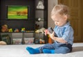 Cute baby boy playing with the remote control on a couch in the living room at home Royalty Free Stock Photo