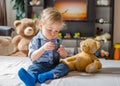 Cute baby boy playing with the remote control on a couch in the living room at home Royalty Free Stock Photo