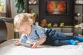 Cute baby boy playing with the remote control on a couch in the living room at home Royalty Free Stock Photo