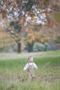 Cute baby boy running through Autumn leaves Royalty Free Stock Photo