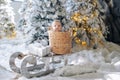 Cute baby boy sits inside of wicker basket on sled among artificial snow and Christmas trees Royalty Free Stock Photo