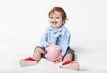 Cute baby boy sitting on floor with piggy bank Royalty Free Stock Photo