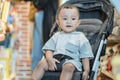 cute baby boy sitting on a stroller in the shopping mall