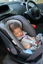 Cute baby boy sleeping in car seat safety belt lock protection drive road Royalty Free Stock Photo