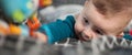 Cute baby boy stretches out his hand towards the camera in front and tries to reach and touch the toy