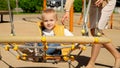 Cute baby boy swinging with mother in spider web swing on playground. Children playing outdoor, kids outside, summer holiday and Royalty Free Stock Photo