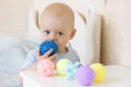 Cute baby boy toddler playing with prickly massage ball.