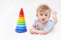 Cute baby boy with toy pyramid on light background Royalty Free Stock Photo