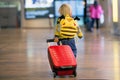 Cute  baby boy waiting boarding to flight in airport transit hall near departure gate. Active family lifestyle travel by air with Royalty Free Stock Photo