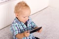 Cute baby boy watching cartoons in smartphone. Funny toddler playing with phone Royalty Free Stock Photo