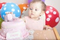 Cute baby celebrating first birthday and eating cake.