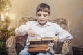 Cute baby in a chair reading a book in interior Royalty Free Stock Photo