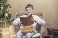 Cute baby in a chair reading a book in interior Royalty Free Stock Photo