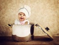 Cute baby chef in a huge cauldron