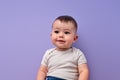 Cute Baby child with sweet cute facial expression posing at camera isolated on purple Royalty Free Stock Photo