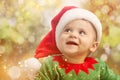 Cute baby in Christmas costume against blurred lights. Magical festive atmosphere