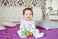 Cute baby, close up. Portrait of a crawling baby on the bed in her room