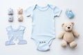 Cute baby clothes for boy and girl, rattle, bottle and dummy space in the middle, on white background top view. AI Royalty Free Stock Photo