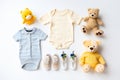 Cute baby clothes for boy and girl, rattle, bottle and dummy space in the middle, on white background top view. AI Royalty Free Stock Photo