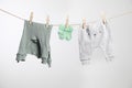 Cute baby clothes drying on washing line against white background Royalty Free Stock Photo