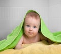 Cute baby in colorful bathing towel in bathroom