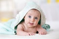 Cute baby covered with a bath towel lying on tummy in the bathroom Royalty Free Stock Photo