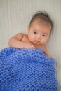 Cute baby covered in blue towel quilt making various expressions