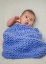 Cute baby covered in blue towel quilt making various expressions