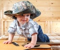 Cute baby in cowboy hat climbing the guitar Royalty Free Stock Photo