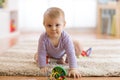 Cute baby crawling on the floor in nursery room Royalty Free Stock Photo
