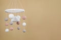 Cute baby crib mobile on beige background. Space for text Royalty Free Stock Photo