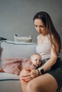 Cute baby daughter in an elegant dress lies on her mother& x27;s knees Royalty Free Stock Photo