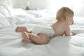 Cute baby in diaper lying on bed at home Royalty Free Stock Photo