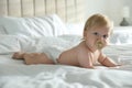 Cute baby in diaper with pacifier lying on bed at home Royalty Free Stock Photo