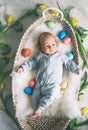 Cute baby Easter bunny. Little baby boy with bunny ears and Easter eggs in wicker basket in white fur. Symbol of Easter holiday, Royalty Free Stock Photo