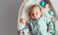 Cute baby Easter bunny. Little baby boy with bunny ears and Easter eggs in wicker basket in white fur. Symbol of Easter holiday, Royalty Free Stock Photo